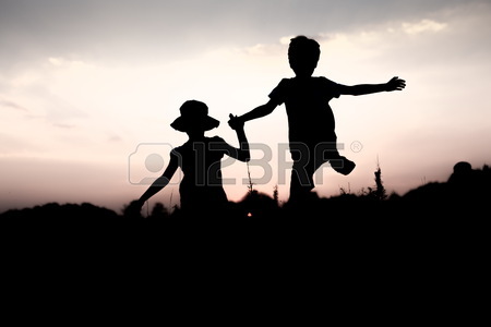 450x300 Silhouettes Of Kids Jumping Off A Cliff At Sunset. Boy And Girl